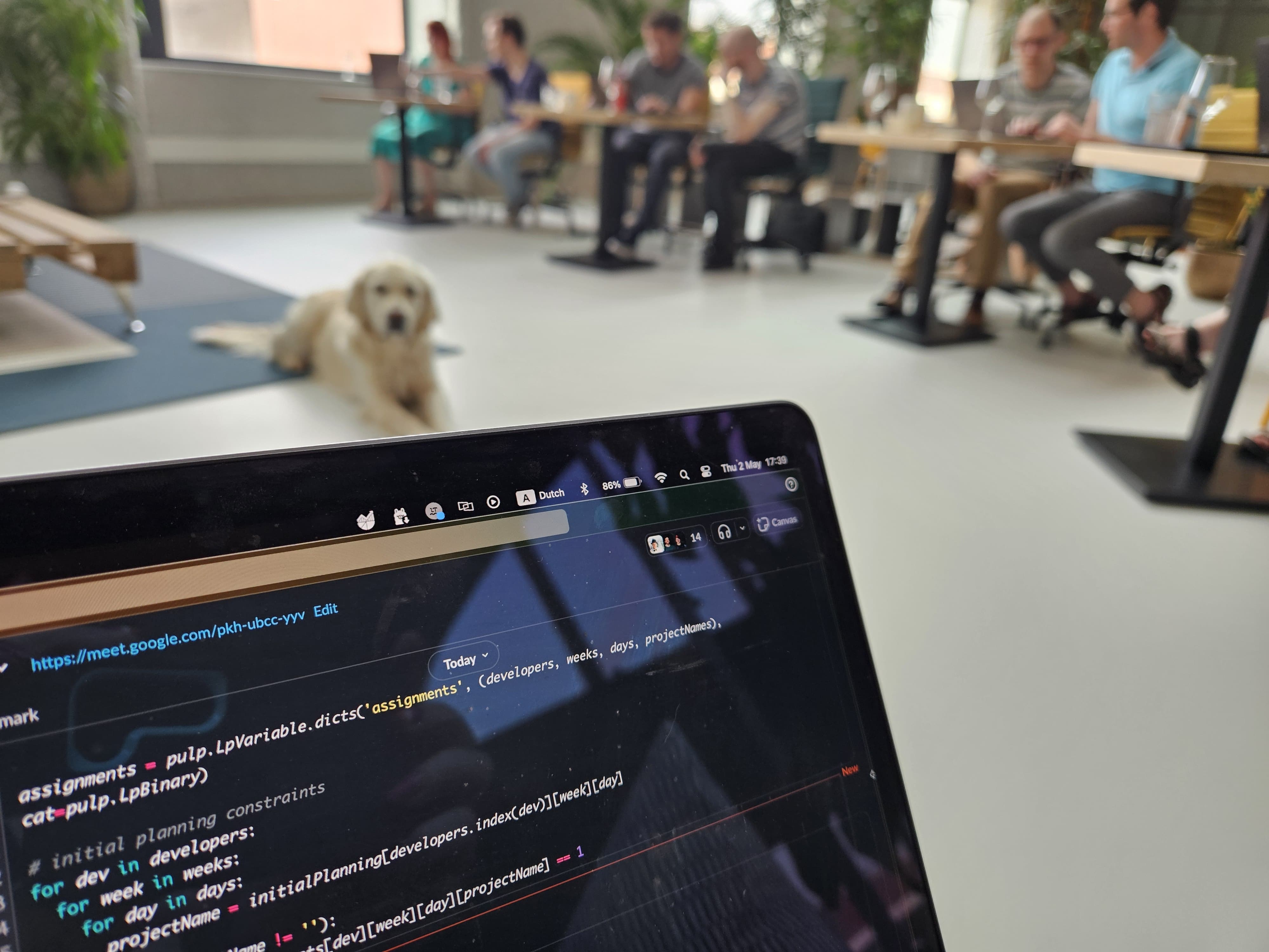 Code on a screen, with Pippa and colleagues in the background